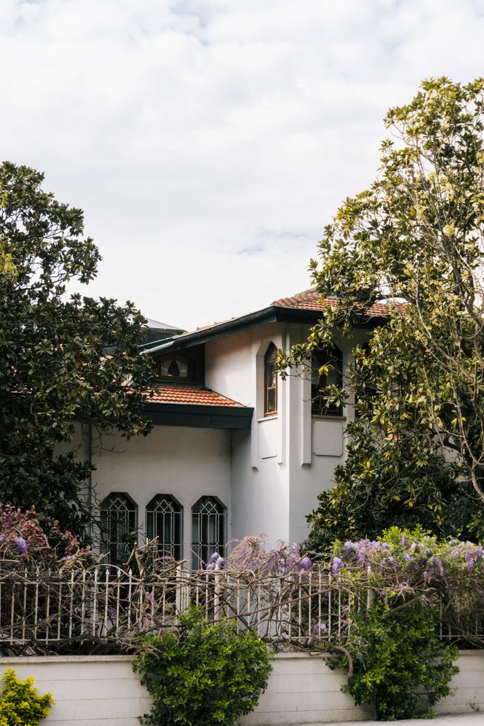 Elegant house surrounded by lush greenery and overcast sky. Perfect for architectural and real estate themes.